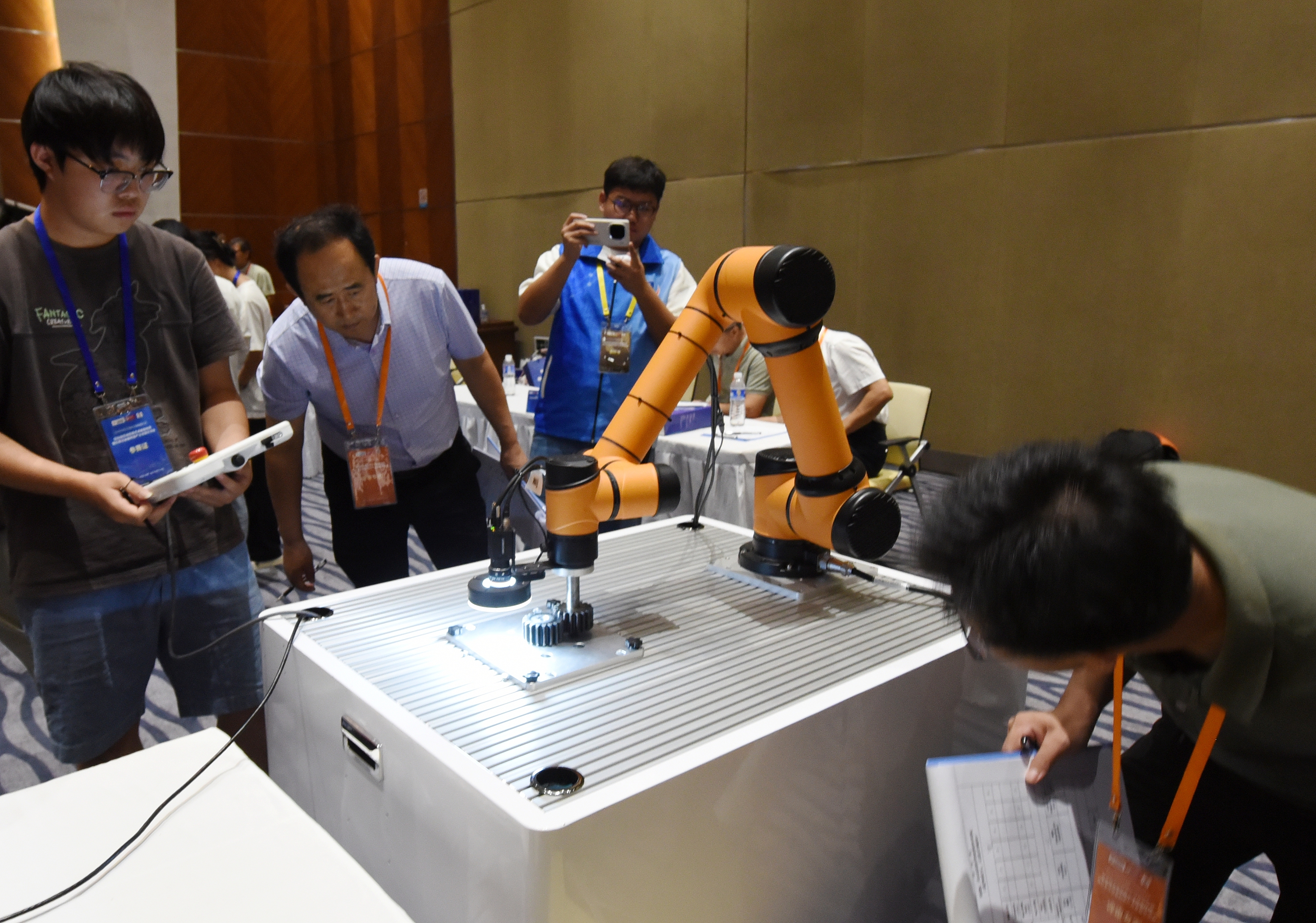 2025年中國大學(xué)生機械工程創(chuàng)新創(chuàng)意大賽智能精密裝配賽京津冀魯聯(lián)賽現(xiàn)場，評委對參賽選手進(jìn)行實操調(diào)試評比。